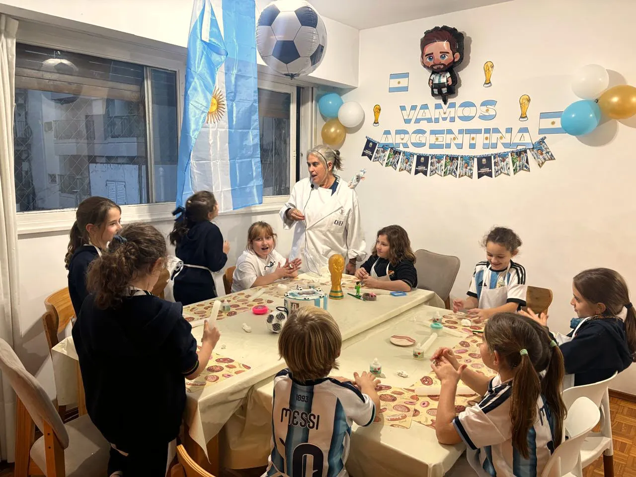 La sala del cumpleaños, con Mariana explicando y los chicos en sus estaciones