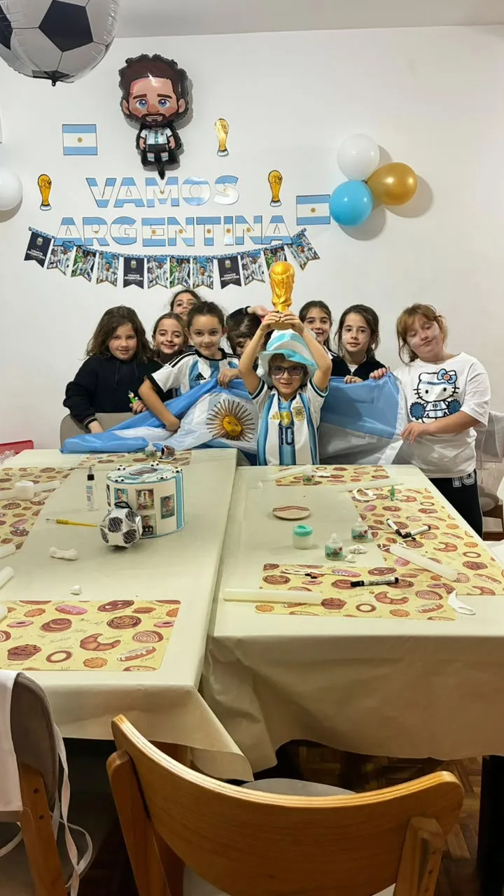 Un grupo de chicas levantando la bandera y la copa en el cumpleaños