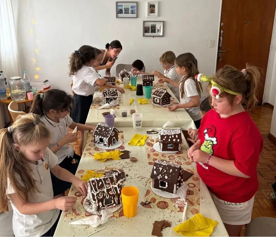 Chicos armando casitas de galletita en un taller temático
