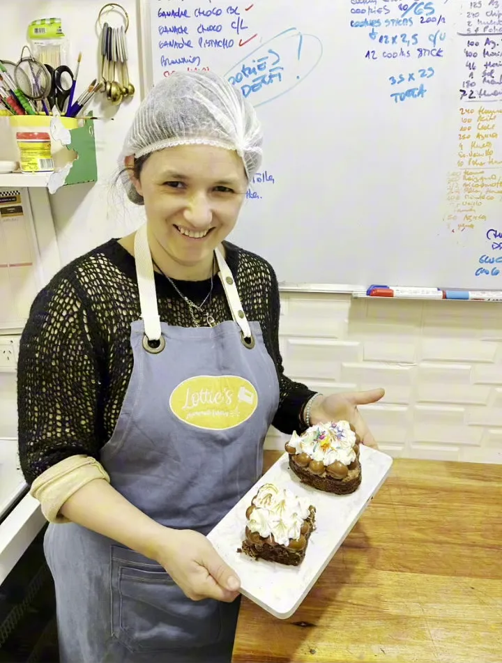 Una alumna adulta con su torta terminada en la bandeja